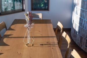 une table en bois avec un vase de fleurs dessus dans l'établissement Costa de Rias Izu-Atagawa - Vacation STAY 11110v, à Okawa