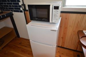 a microwave sitting on top of a refrigerator at GRANDPA'S HOUSE Barchanchi - Vacation STAY 53569v in Naha