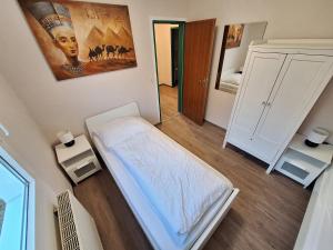 a small room with a bed and a mirror at Elbidylle Ferienwohnung in Barby am Elberadweg in Barby