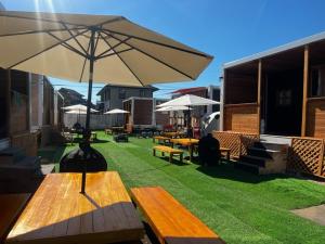 a patio with benches and tables with an umbrella at Glamping Village Leaf - Vacation STAY 65726v in Mashiki