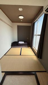 大阪市にあるNamba Ambers Hostel 6604のベッドが2つと窓がある小さな部屋