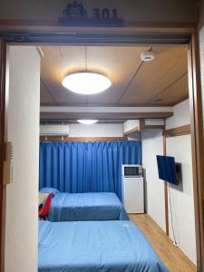 a room with two beds and a blue curtain at Kawaramachi Station · home - Vacation STAY 37891v in Takamatsu