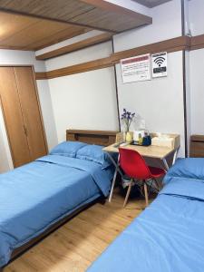 a room with two beds and a table with a desk at Kawaramachi Station · home - Vacation STAY 37891v in Takamatsu +2 photos