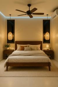 a bedroom with a large bed with a ceiling fan at KUUL Villas in Baan Tai