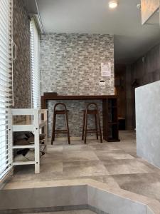 a room with two stools and a counter with a brick wall at Eight Beat Building - Vacation STAY 44869v in Tokyo