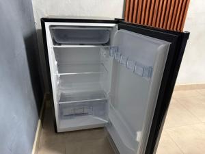 ein leerer Kühlschrank mit offener Tür in einem Zimmer in der Unterkunft Sayula Suites Hotel in Sayula