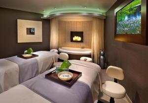 Atlantis Casino Resort Spa في رينو: غرفة علاج بها أربعة أسرة وحوض استحمام +124 صورة