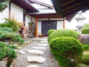 a garden with rocks and bushes in front of a building at Yadoya Sho - Vacation STAY 13531 in Kurume
