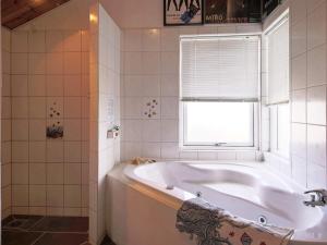a white bath tub in a bathroom with a window at 6 person holiday home in Jægerspris-By Traum in Frederikssund