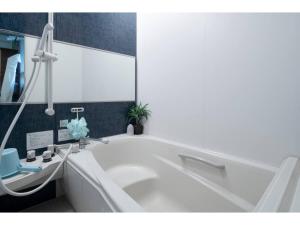 a white bath tub in a bathroom with a sink at Art Salon Hosokawa - Vacation STAY 13628 in Sapporo +16 photos