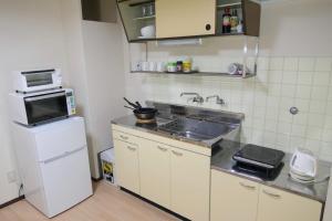 a small kitchen with a sink and a microwave at Aoisora Aoiumi no guest house - Vacation STAY 74130v in Takamatsu
