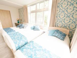 a bedroom with three beds with blue and white sheets at Villa East Hana - Vacation STAY 76042v in Nago