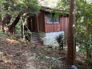 une petite maison avec un garage dans les bois dans l'établissement Yamagoya limelight - Vacation STAY 79313v, à Okawa