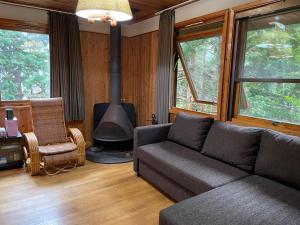 - un salon avec un canapé et un poêle à bois dans l'établissement Yamagoya limelight - Vacation STAY 79313v, à Okawa
