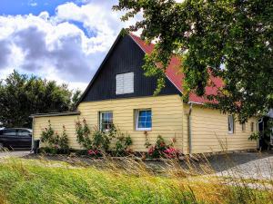 a small yellow house with a black roof at Appartement Solbakke in Østermarie
