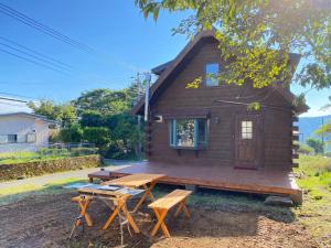 Une petite maison avec une table de pique-nique et des bancs dans l'établissement Trust Maison Hoshizora Resort Shirata - Vacation STAY 83049v, à Higashiizu