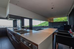 una cucina con bancone, lavandino e finestre di Sapporo - House - Vacation STAY 13790 a Sapporo