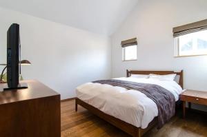 a bedroom with a bed and a flat screen tv at TOOD Ichinomiya - Vacation STAY 97261v in Ichinomiya