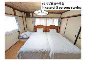 ein Schlafzimmer mit einem großen weißen Bett für den Fall, dass mehrere Personen übernachten in der Unterkunft Corp Temma - Vacation STAY 08268v in Takayama
