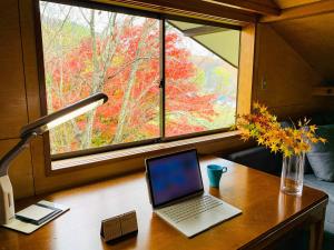 a laptop computer sitting on a desk in front of a window at NAKAO VILLA - Vacation STAY 15671v in Nozawa Onsen