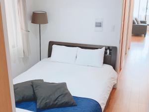 a bedroom with a large bed with white sheets and pillows at ＥＵＲＯＰＥＡＮ ＨＯＵＳＥ ＲＥＩＳＥＮ - Vacation STAY 10505v in Fukuoka