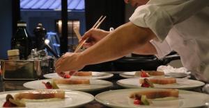 a chef preparing food on white plates on a counter at Satoyama villa DEN - Vacation STAY 17844 in Matsumoto