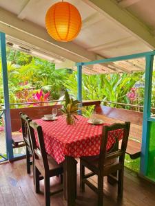 a table with a red table cloth on a porch at Ita Ita Casitas Family Vacation Playa Punta Uva in Punta Uva
