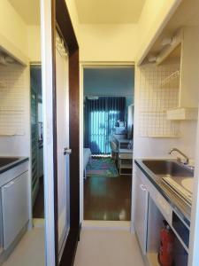 una cucina con un lavello e una porta che dà sul soggiorno di Glen Stage 102 - Vacation STAY 13962 a Saitama Altre 7 foto