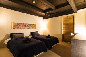 Zimmer mit 2 Betten mit schwarzer Bettwäsche und einem Gemälde in der Unterkunft Wellis Villa Awaji - Vacation STAY 15883 in Ikuta + 70 Fotos