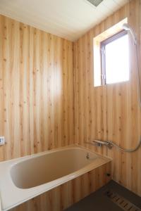 a bath tub in a wooden bathroom with a window at Renesto aHOLIDAYHOME - Vacation STAY 27971v in Kobe