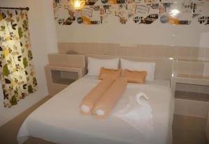 białe łóżko z dwoma składanymi ręcznikami w obiekcie Saraburi Garden Resort w mieście Prowincja Saraburi