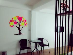 a table and chairs in a room with a tree on the wall at The Pride Hotel At Laemsing in Laem Sing +78 photos