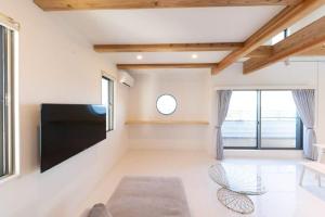 a living room with a flat screen tv on the wall at Kanasha Building A - Vacation STAY 28224v in Ōkachi