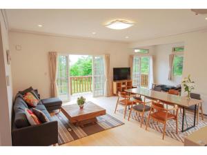 Una sala de estar con una mesa y un comedor. en Polar House Asama Terrace - Vacation STAY 30335v, en Oiwake