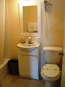y baño con aseo, lavabo y espejo. en Prime Inn - Rio Grande, en Rio Grande
