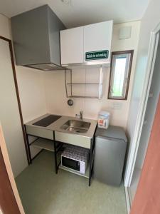 a small kitchen with a sink and a refrigerator at Kai sou - Vacation STAY 43055v in Tateyama