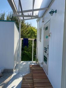 a white building with a wooden walkway next to a door at Kai sou - Vacation STAY 43055v in Tateyama