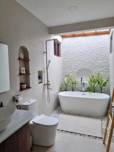 Un baño con bañera, inodoro y lavabo. en Balay Vicente, en Tarlac