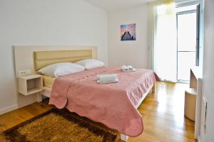a bedroom with a bed with a pink blanket at Apartment Domalu Old Town in Zadar