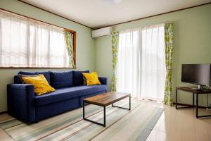 a living room with a blue couch and a tv at Twilight Villa Onjuku - Vacation STAY 52776v in Iwada