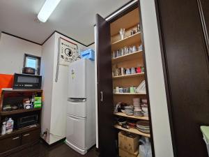 a kitchen with a refrigerator and a shelf with dishes at Ikinomannaka - Vacation STAY 58080v in Iki +30 photos