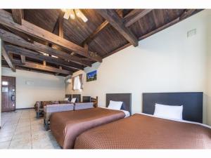 two beds in a room with wooden ceilings at Nagura Village - Vacation STAY 61123v in Kabira +40 photos