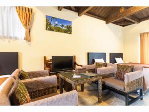 a living room with couches and a flat screen tv at Nagura Village - Vacation STAY 61123v in Kabira