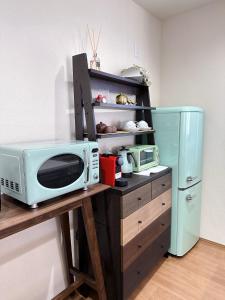 eine Mikrowelle auf einem Tisch neben einem Kühlschrank in der Unterkunft Villa Sanmado Panorama BBQ Bonfire Fuji view Annov - Vacation STAY 59398v in Fujikawaguchiko