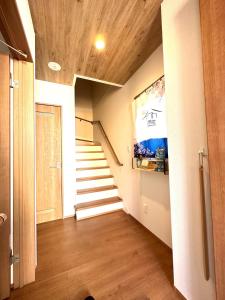 einen Flur mit Treppen in einem Haus mit Holzdecken in der Unterkunft Villa Sanmado Panorama BBQ Bonfire Fuji view Annov - Vacation STAY 59398v in Fujikawaguchiko