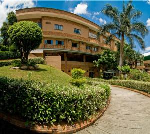 un edificio con un árbol delante de él en Hotel Palmera Real, en Bucaramanga