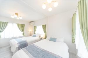 two beds in a white room with windows at Yokkaichi City - House - Vacation STAY 68977v in Nishi-hino