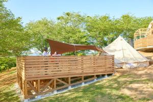 a couple of people standing on a wooden deck next to a tent at hanaya satoyama - Vacation STAY 72049v in Ishioka