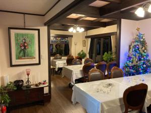 una sala da pranzo con un albero di Natale e tavoli di Auberge Chez CODERA - Vacation STAY 76332v a Katsuura
