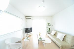 a white living room with a couch and a tv at Yokkaichi - House - Vacation STAY 68949v in Yokkaichi